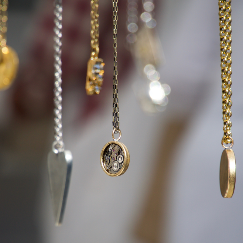 Mixed metal necklaces hanging up.